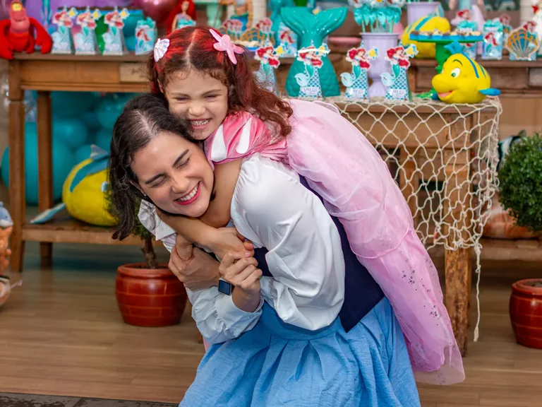 Fotografia afetiva de festa infantil no Rio de Janeiro: mãe e filha se abraçando em aniversário tema Pequena Sereia, Pirralhitus